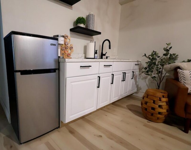 103 Cottonwood Ct, Litchfield, MI 49252 - bar featuring freestanding refrigerator and light wood-style flooring