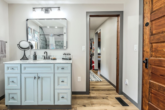 3360 Broad St, Dexter, MI 48130 - bathroom with wood finished floors, vanity, and a shower with curtain