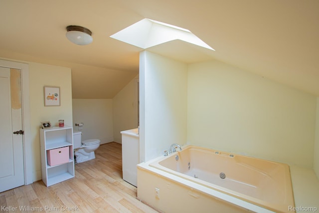 235 E Saint Clair St, Almont, MI 48003 - bathroom with a skylight, vaulted ceiling, a whirlpool tub, and wood finished floors