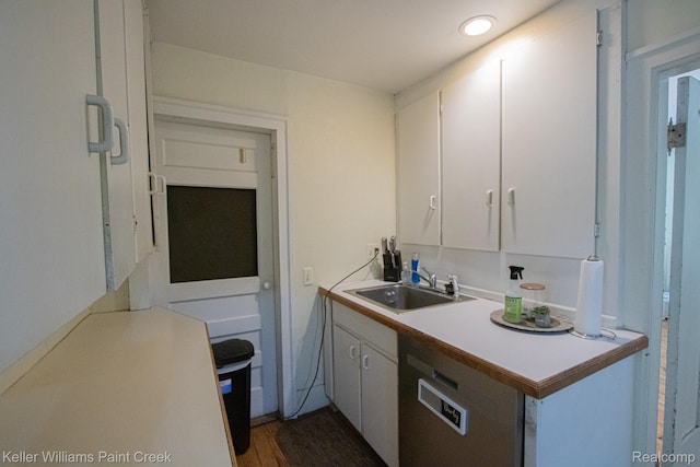 235 E Saint Clair St, Almont, MI 48003 - kitchen featuring white cabinetry, light countertops, dark wood-style floors, and dishwasher