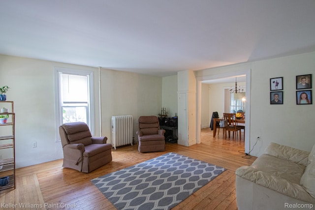 235 E Saint Clair St, Almont, MI 48003 - living area featuring radiator, a chandelier, and light wood-style flooring
