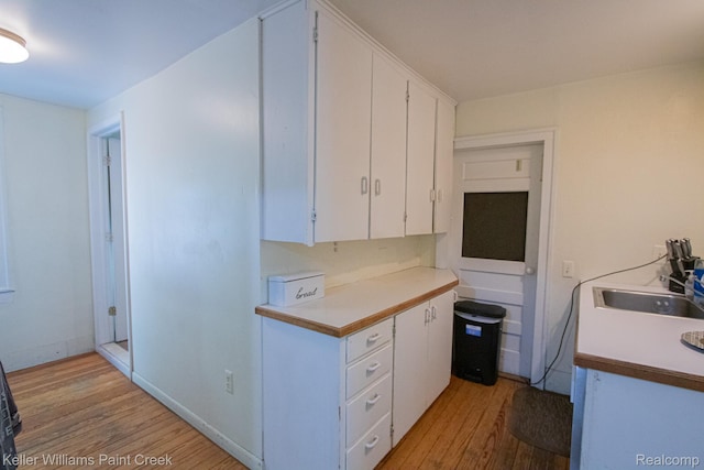 235 E Saint Clair St, Almont, MI 48003 - kitchen with light wood finished floors, white cabinets, and light countertops