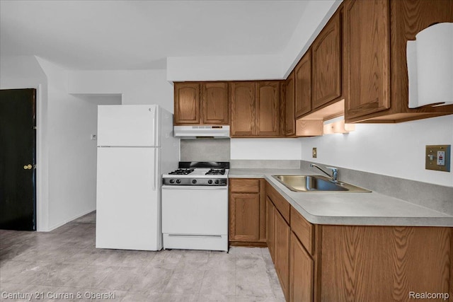 23505 Baker St, Taylor, MI 48180 - kitchen featuring white appliances, under cabinet range hood, brown cabinetry, and light countertops