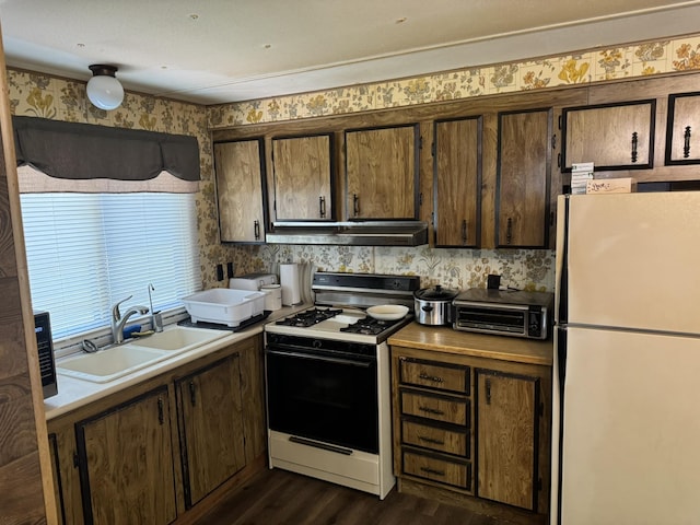 1321 Ziggy Rd, Farwell, MI 48622 - kitchen featuring freestanding refrigerator, gas stove, under cabinet range hood, dark wood finished floors, and dark brown cabinets