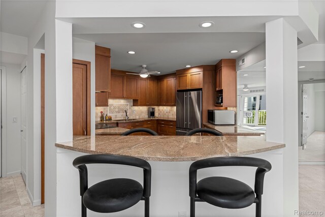 3565 Port Cove Dr Unit 68, Waterford, MI 48328 - kitchen with high quality fridge, a ceiling fan, white microwave, a breakfast bar, and recessed lighting