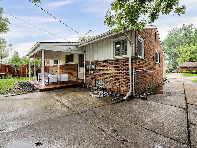22854 Lingemann St, Saint Clair Shores, MI 48080 - view of front of house featuring brick siding, concrete driveway, board and batten siding, a deck, and a patio area