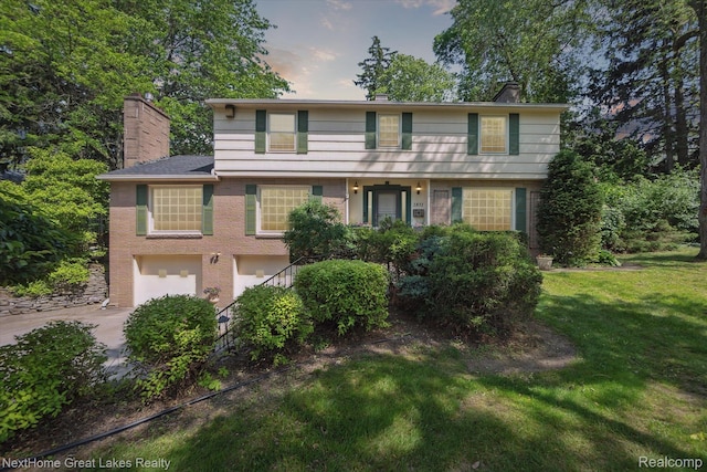 1831 Hampden Rd, Flint, MI 48503 - view of front of property featuring concrete driveway, an attached garage, a chimney, and a front yard