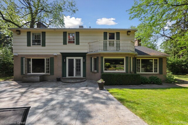 1831 Hampden Rd, Flint, MI 48503 - view of front of home featuring a balcony, brick siding, and a front lawn