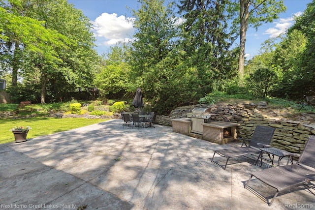 1831 Hampden Rd, Flint, MI 48503 - view of patio / terrace with exterior kitchen, outdoor dining space, and view of wooded area