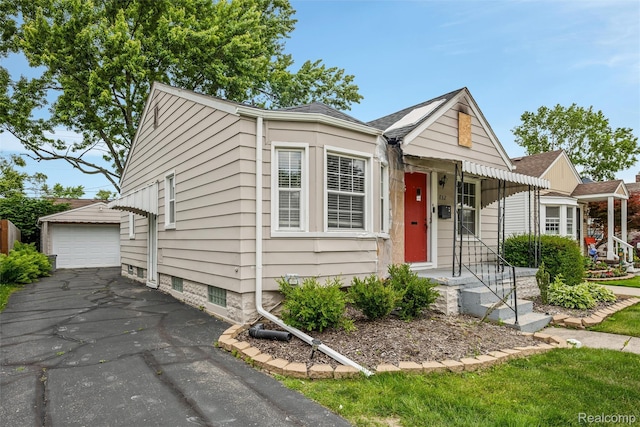 852 Cambridge Rd, Berkley, MI 48072 - view of front of house with a detached garage, an outdoor structure, and asphalt driveway