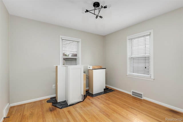 852 Cambridge Rd, Berkley, MI 48072 - unfurnished room featuring light wood-style floors and a chandelier