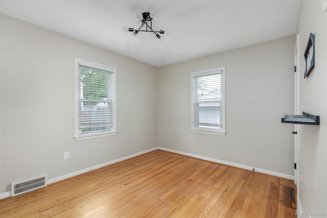 852 Cambridge Rd, Berkley, MI 48072 - empty room with healthy amount of natural light, light wood-type flooring, and a chandelier
