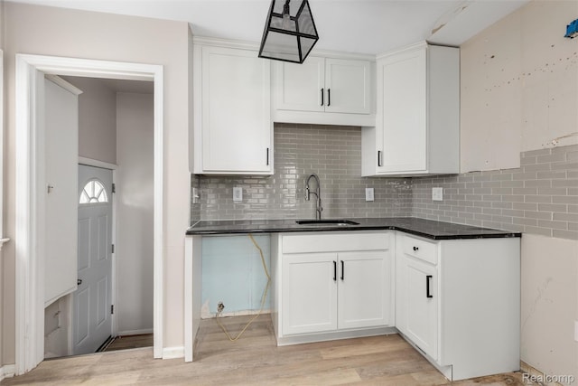 852 Cambridge Rd, Berkley, MI 48072 - kitchen with tasteful backsplash, light wood-style floors, white cabinetry, and dark countertops