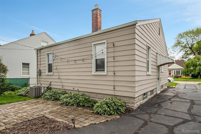 852 Cambridge Rd, Berkley, MI 48072 - view of home's exterior featuring a cooling unit and a chimney
