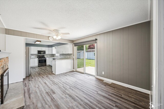 1115 Birchwood Dr, Temperance, MI 48182 - unfurnished living room featuring a fireplace, wood finished floors, ceiling fan, and a textured ceiling