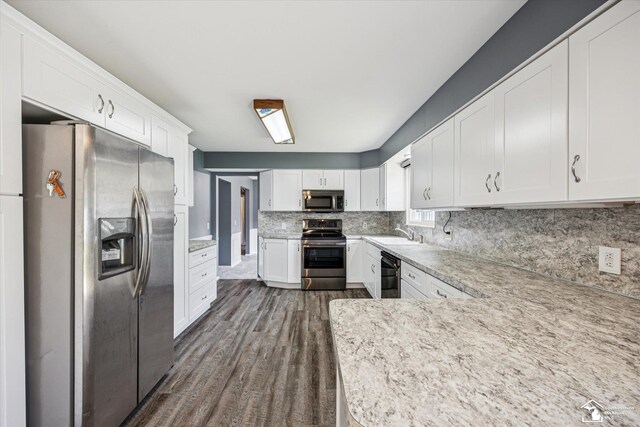 1115 Birchwood Dr, Temperance, MI 48182 - kitchen featuring appliances with stainless steel finishes, dark wood finished floors, white cabinetry, and backsplash