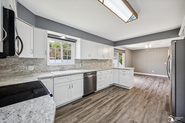 1115 Birchwood Dr, Temperance, MI 48182 - kitchen with appliances with stainless steel finishes, dark wood-style floors, decorative backsplash, and white cabinetry