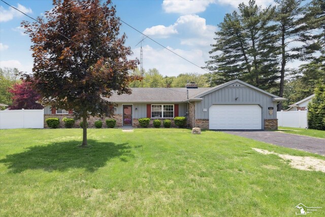 1115 Birchwood Dr, Temperance, MI 48182 - view of front of property featuring an attached garage, driveway, a chimney, and board and batten siding