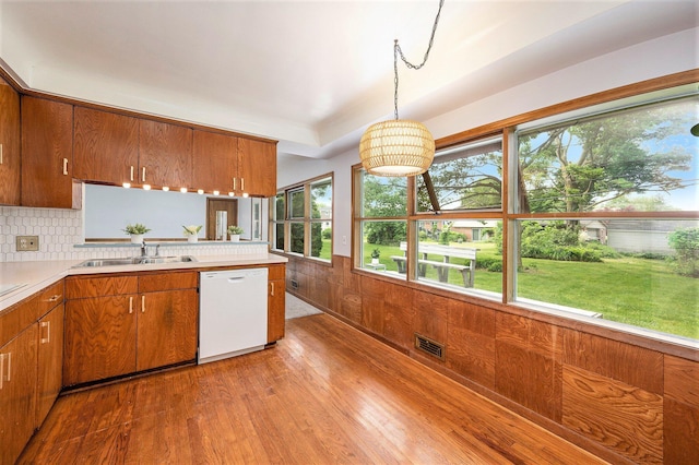 30151 Westfield St, Farmington Hills, MI 48334 - kitchen featuring white dishwasher, brown cabinets, light wood-style floors, light countertops, and tasteful backsplash