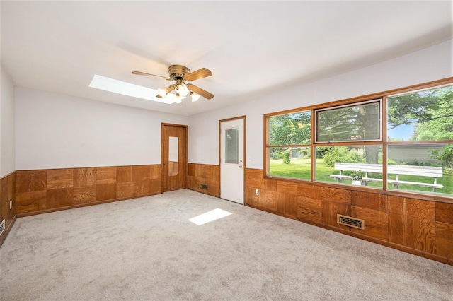 30151 Westfield St, Farmington Hills, MI 48334 - unfurnished room featuring a skylight, wainscoting, a ceiling fan, carpet flooring, and wooden walls