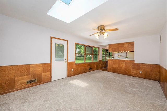 30151 Westfield St, Farmington Hills, MI 48334 - carpeted spare room with wainscoting, a skylight, wooden walls, and a ceiling fan