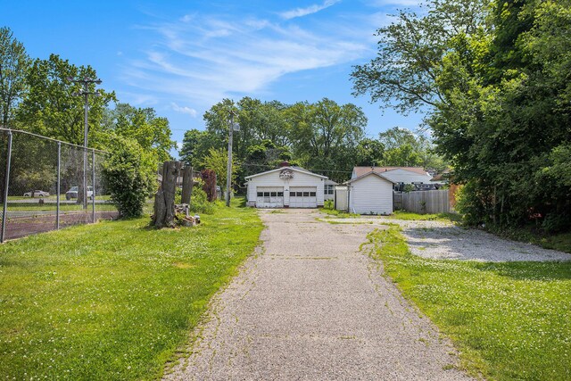 716 Langrick St, Sturgis, MI 49091 - view of front of home featuring a garage, an outbuilding, and view of wooded area