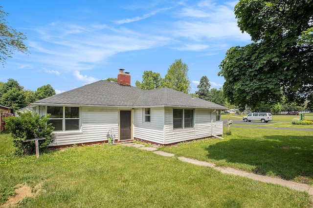 716 Langrick St, Sturgis, MI 49091 - rear view of house with a chimney, a yard, and roof with shingles
