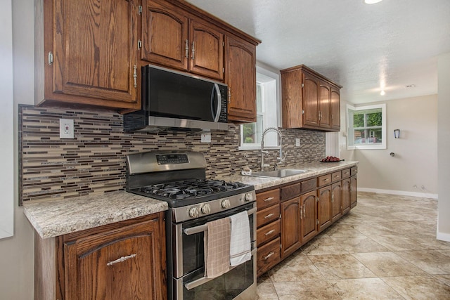 716 Langrick St, Sturgis, MI 49091 - kitchen with stainless steel appliances, tasteful backsplash, light countertops, and brown cabinetry