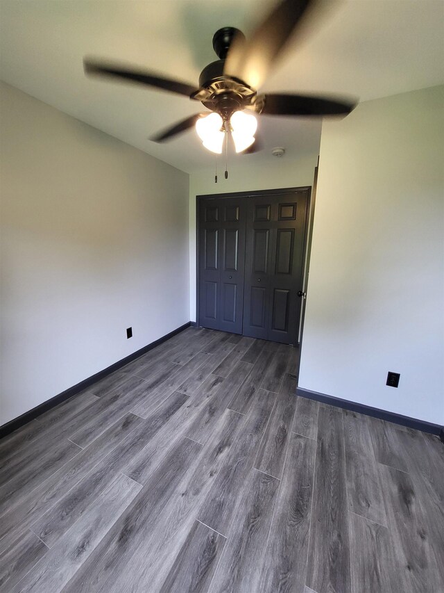 3456 N Irish Rd, Davison, MI 48423 - unfurnished bedroom featuring dark wood-style floors, a closet, and a ceiling fan