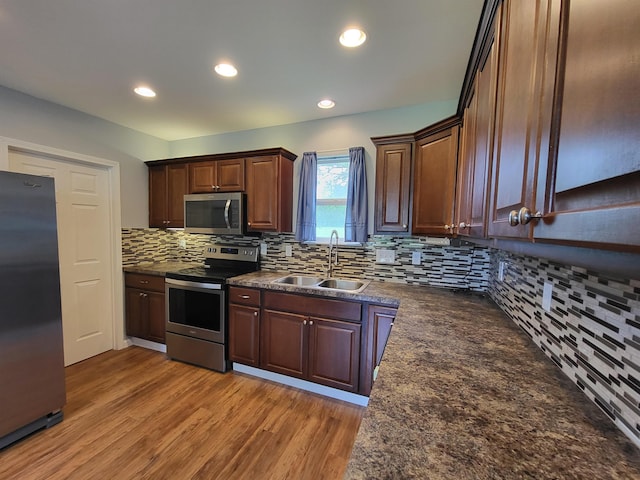 3456 N Irish Rd, Davison, MI 48423 - kitchen with appliances with stainless steel finishes, dark countertops, tasteful backsplash, light wood-style flooring, and recessed lighting
