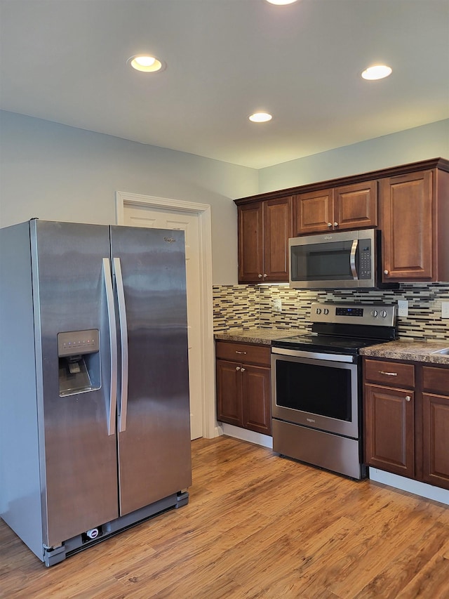 3456 N Irish Rd, Davison, MI 48423 - kitchen with appliances with stainless steel finishes, backsplash, light wood finished floors, recessed lighting, and dark brown cabinetry
