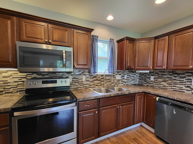 3456 N Irish Rd, Davison, MI 48423 - kitchen featuring stainless steel appliances, tasteful backsplash, light wood-type flooring, recessed lighting, and dark countertops