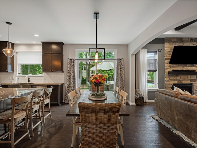 13531 Brampton Ct, Utica, MI 48315 - dining space with healthy amount of natural light, recessed lighting, a fireplace, dark wood-style floors, and arched walkways