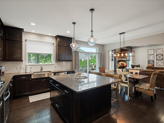 13531 Brampton Ct, Utica, MI 48315 - kitchen with healthy amount of natural light, light stone countertops, dark wood-type flooring, open floor plan, and recessed lighting