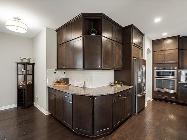 13531 Brampton Ct, Utica, MI 48315 - kitchen featuring appliances with stainless steel finishes, dark wood-style floors, dark brown cabinetry, light stone countertops, and recessed lighting