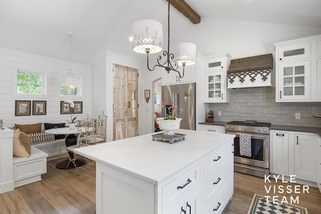 3 Woodward Ln SE, Grand Rapids, MI 49506 - kitchen with stainless steel appliances, premium range hood, wood finished floors, tasteful backsplash, and white cabinetry