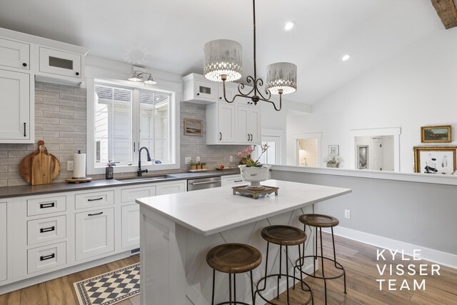 3 Woodward Ln SE, Grand Rapids, MI 49506 - kitchen featuring light wood-style flooring, a breakfast bar, backsplash, a kitchen island, and recessed lighting