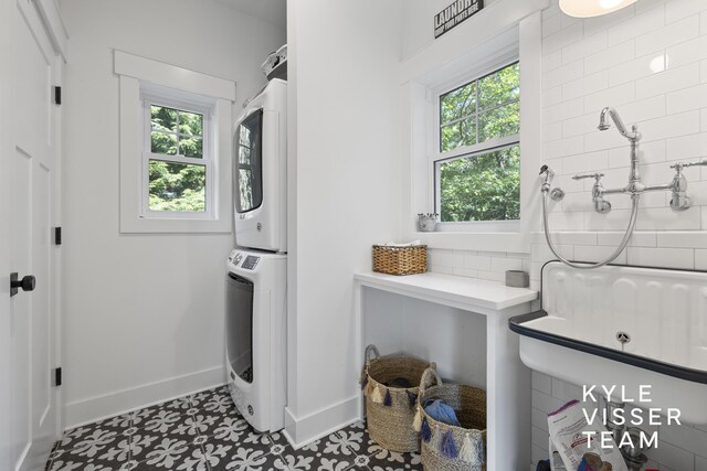 3 Woodward Ln SE, Grand Rapids, MI 49506 - laundry room featuring stacked washing machine and dryer and baseboards