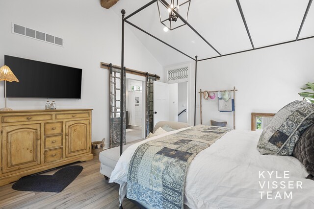 3 Woodward Ln SE, Grand Rapids, MI 49506 - bedroom featuring a barn door, high vaulted ceiling, and light wood-style flooring