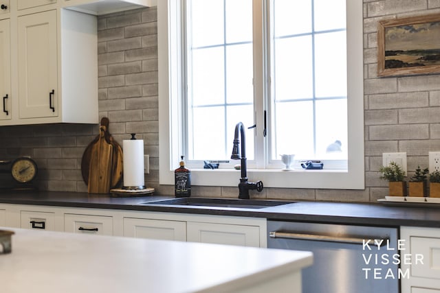 3 Woodward Ln SE, Grand Rapids, MI 49506 - kitchen featuring dishwasher, tasteful backsplash, white cabinets, and dark countertops