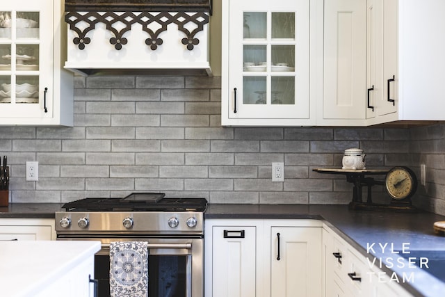 3 Woodward Ln SE, Grand Rapids, MI 49506 - kitchen featuring stainless steel gas stove, white cabinetry, backsplash, and glass insert cabinets