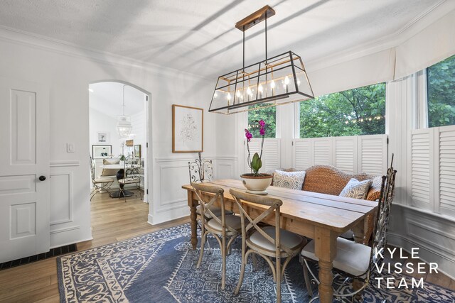 3 Woodward Ln SE, Grand Rapids, MI 49506 - dining room with crown molding, arched walkways, plenty of natural light, wood finished floors, and a wainscoted wall