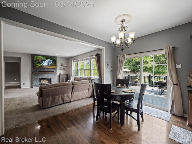 7235 Goldenrod Ct, Brighton, MI 48116 - dining area featuring a chandelier, a fireplace, and wood finished floors
