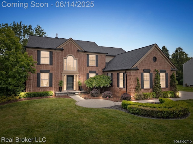 7235 Goldenrod Ct, Brighton, MI 48116 - colonial home with brick siding, a front lawn, and a shingled roof