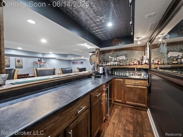 7235 Goldenrod Ct, Brighton, MI 48116 - indoor wet bar with dark wood finished floors, beverage cooler, recessed lighting, an ornate ceiling, and a tray ceiling