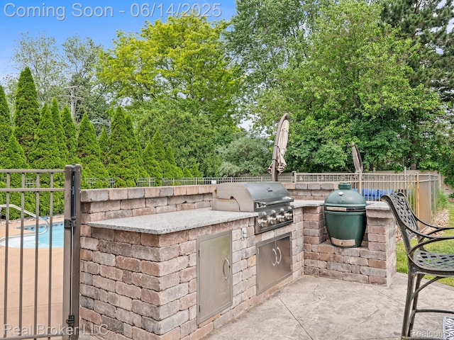 7235 Goldenrod Ct, Brighton, MI 48116 - view of patio / terrace with an outdoor kitchen and view of wooded area