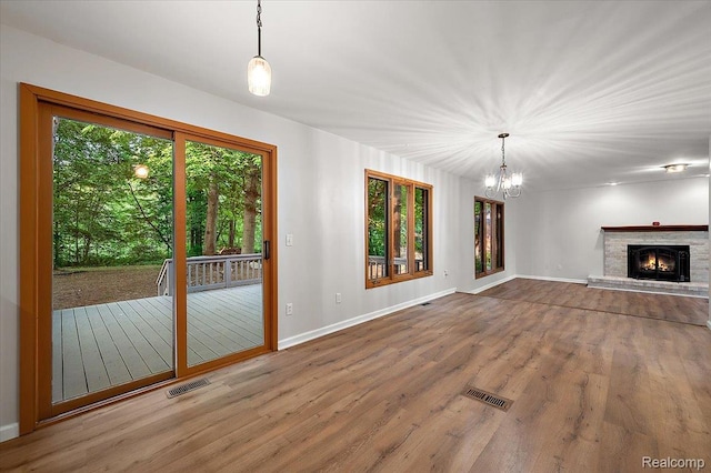 2696 Cedar Key Dr, Lake Orion, MI 48360 - unfurnished living room with a chandelier, wood finished floors, and a brick fireplace