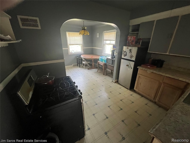6334HERFORD Hereford St, Grosse Pointe, MI 48224 - kitchen with arched walkways, appliances with stainless steel finishes, light floors, and brown cabinetry
