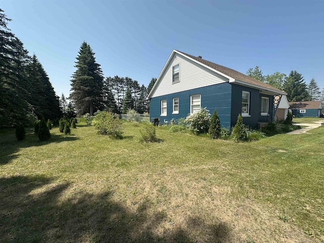 501 W 13th St, Cadillac, MI 49601 - view of side of property with a yard