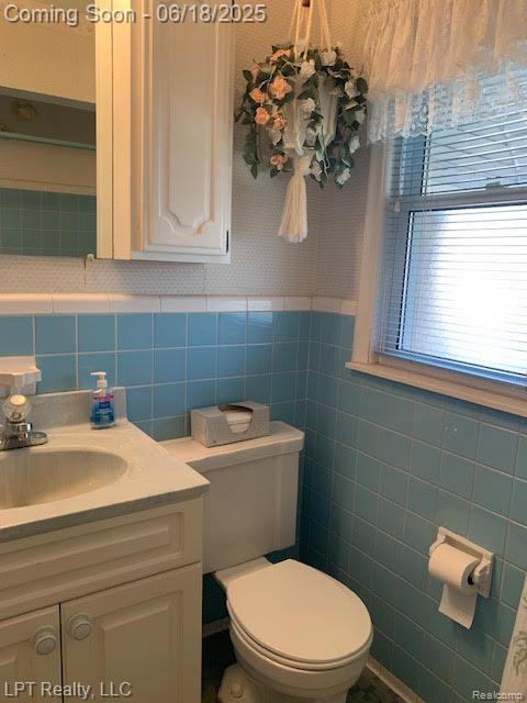 1811 Goddard Rd, Lincoln Park, MI 48146 - bathroom featuring vanity, tile walls, and wainscoting